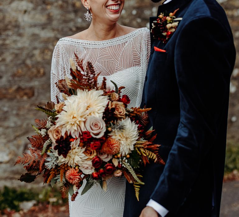 Bride & groom together outdoors with Autumnal bouquet 