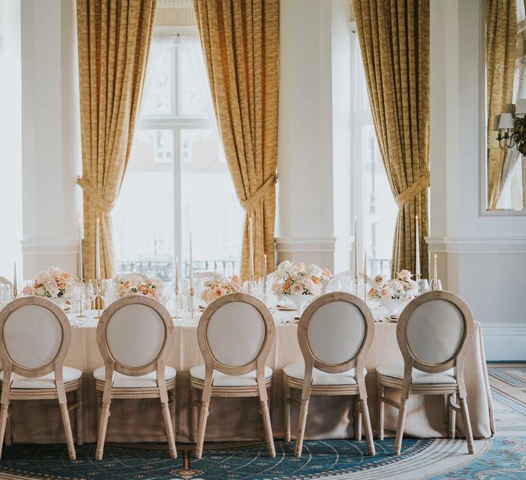 Intimate wedding tablescape at The Landmark London with peach and cream flowers and candle table decor 