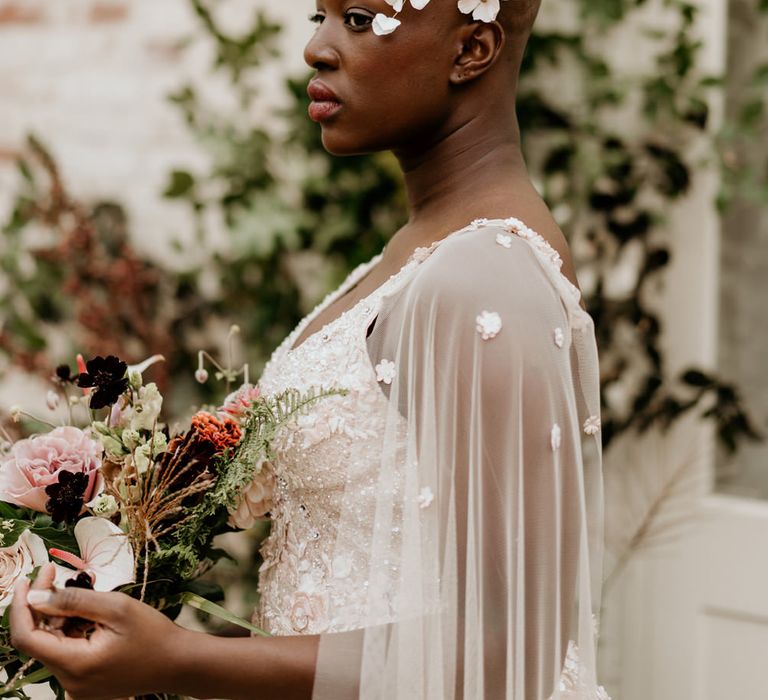 Black bride with alopecia in a floral headdress and bridal cape 