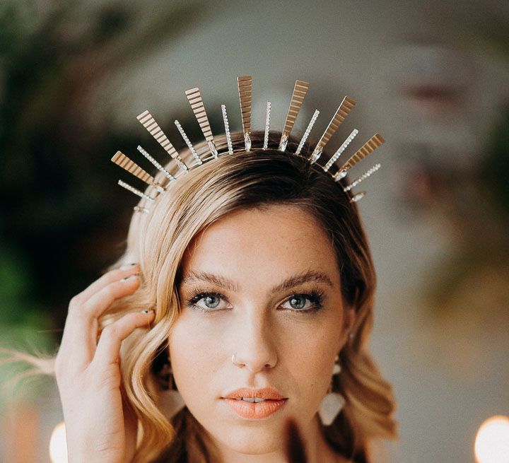 Bride with long wavy blonde hair wearing a gold headdress with smokey eye makeup up and barely there lipstick 