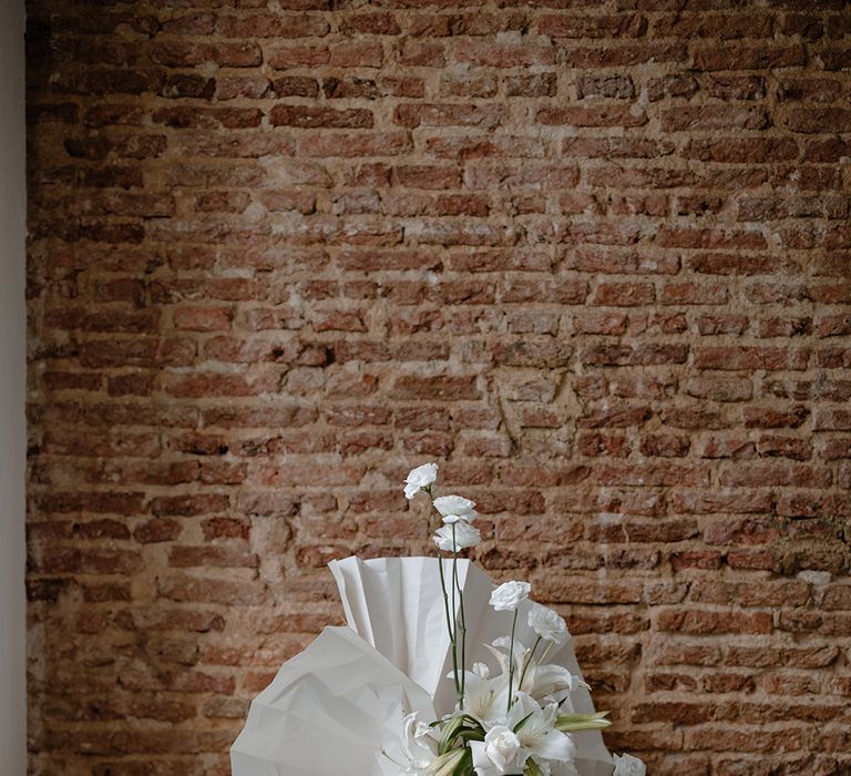 All-white wedding decor with orchid wedding flowers and paper fan