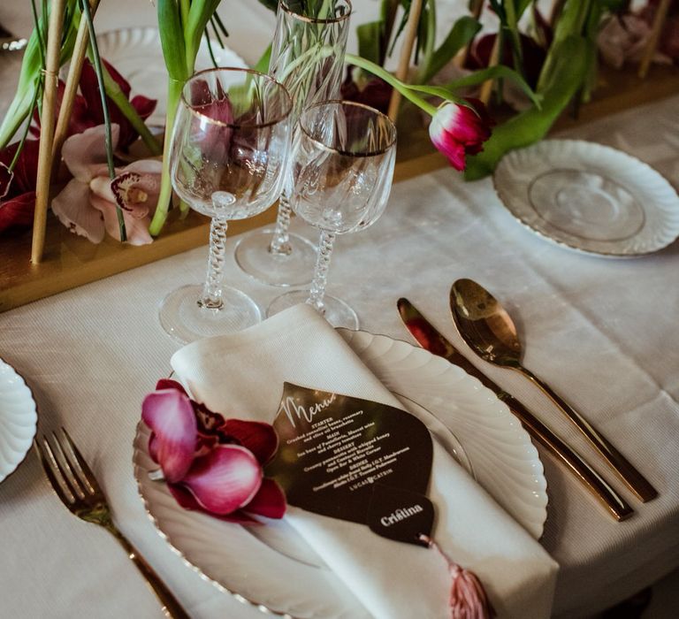 Gold menu and gold rimmed plates and glassware for a glamorous vintage micro wedding