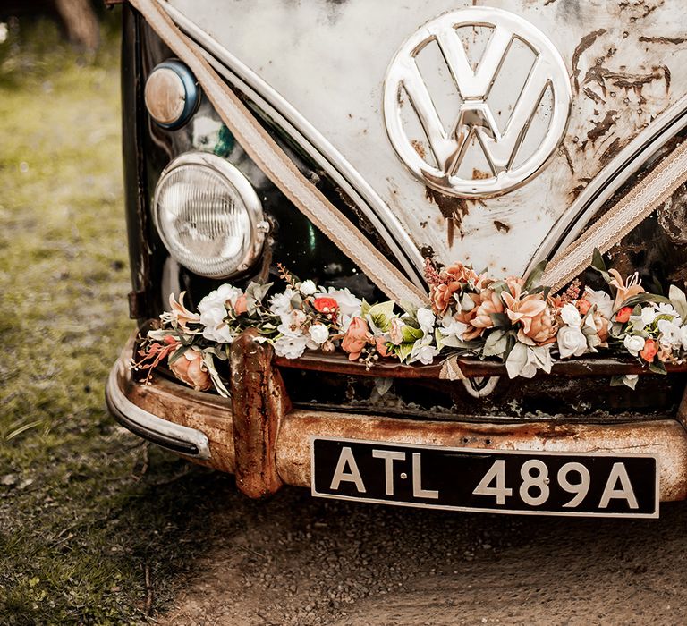 VW camper van decorated with flowers on the bumper 