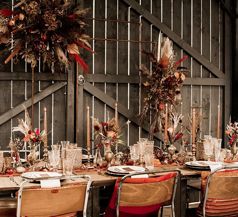 Moroccan inspired table decor at rustic farm wedding with gold lanterns and red and orange wedding flowers 