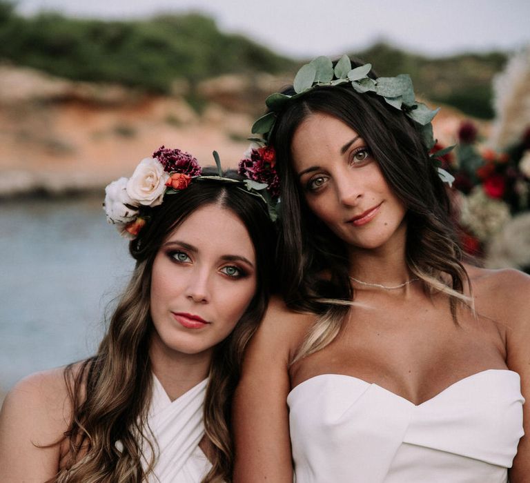 Two brides wearing a strapless Jarlo London gown and adjustable tulle gown, with eucalyptus head bands