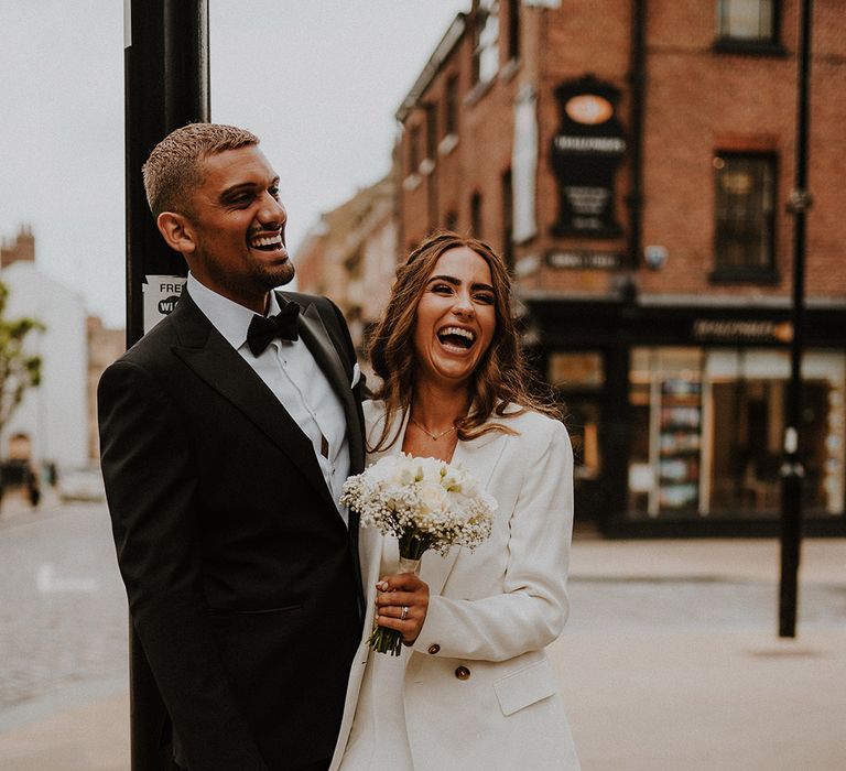 Bride and groom portrait in Sheffield with groom in a tuxedo and bride in a white three-piece suit