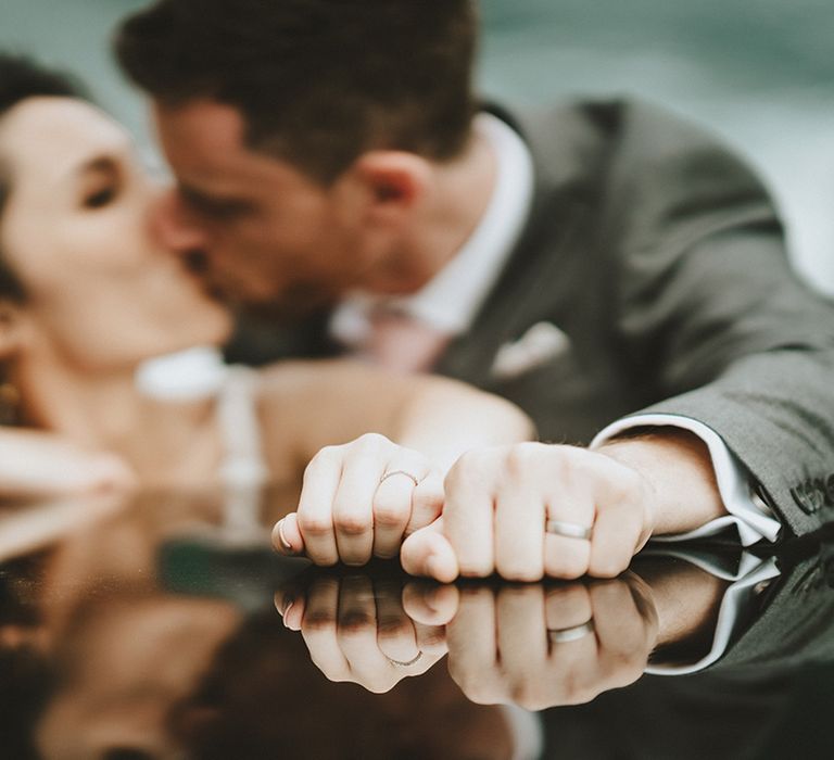 Bride & groom kiss as they show off their wedding rings