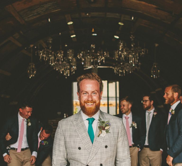 Groom in a light grey check blazer with green tie at Anran wedding in Devon 