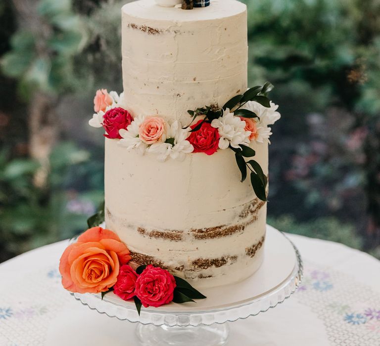 Semi Naked wedding cake with flower decor and wooden peg people cake topper 