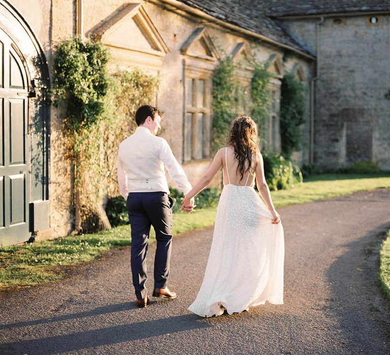 Bride & groom walk through the grounds of Mapperton House whilst the sun shines