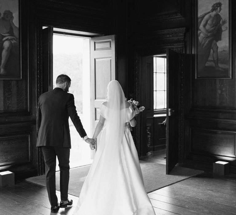 Bride & groom walk hand in hand with one another on their wedding day