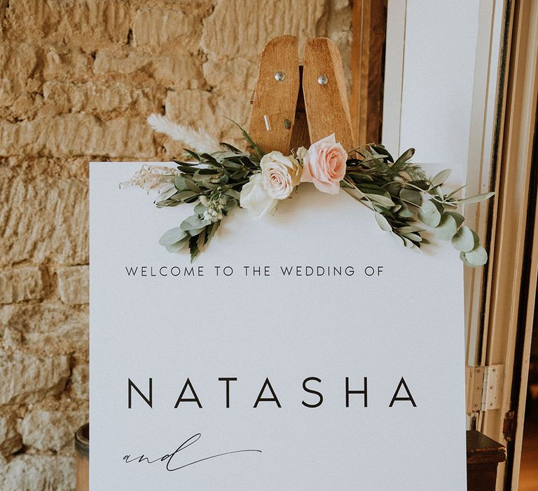 Monochrome wedding sign on wooden easel and rose decor