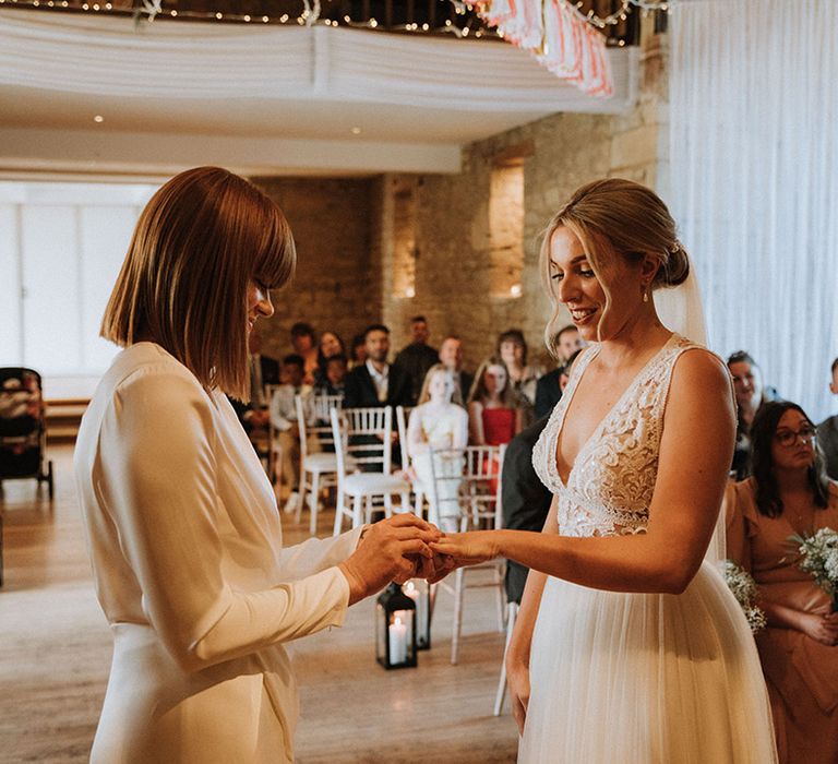 Brides exchange rings at The Great Tythe Barn wedding venue in the Cotswolds