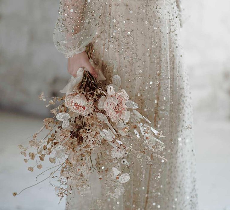 Bride in a sequin wedding dress holding a minimalist dried flower wedding bouquet 