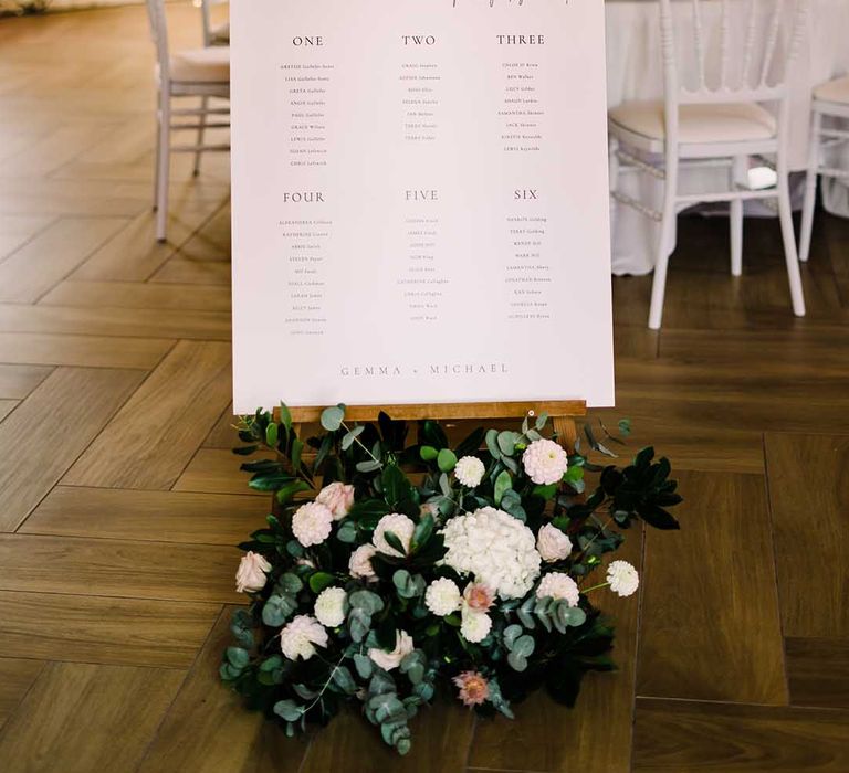 White contemporary stationery on wooden easel complete with floral decor