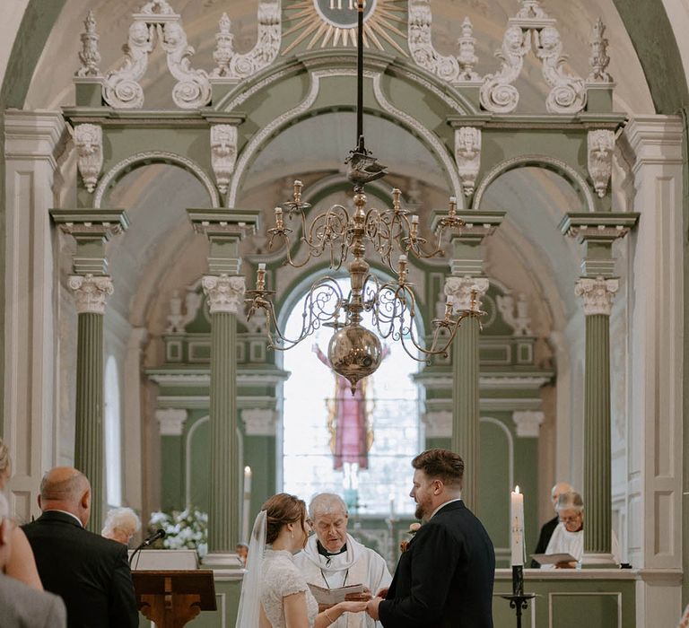 Bride and groom exchange vows at altar