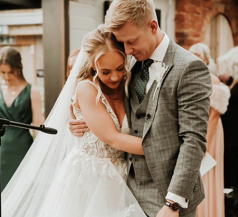 Bride and groom share a hug at wedding ceremony at The Shack Revolution