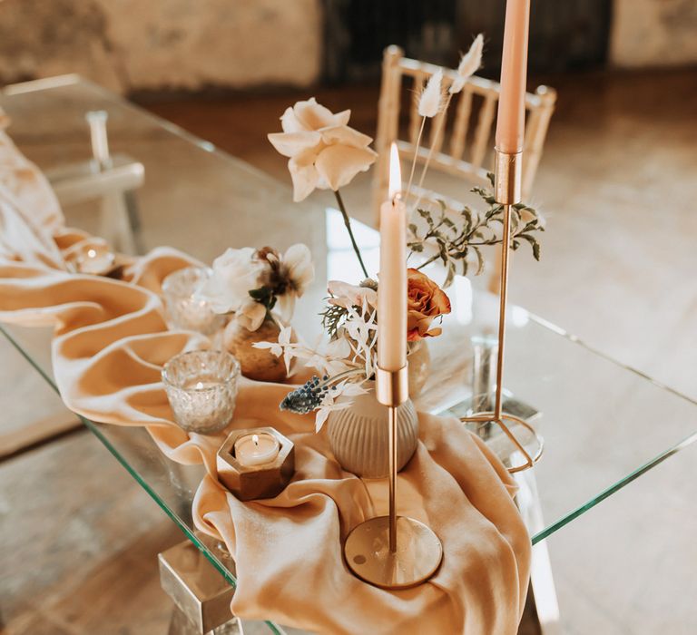 Glass wedding table with draping, pastel florals and pink dinner candles