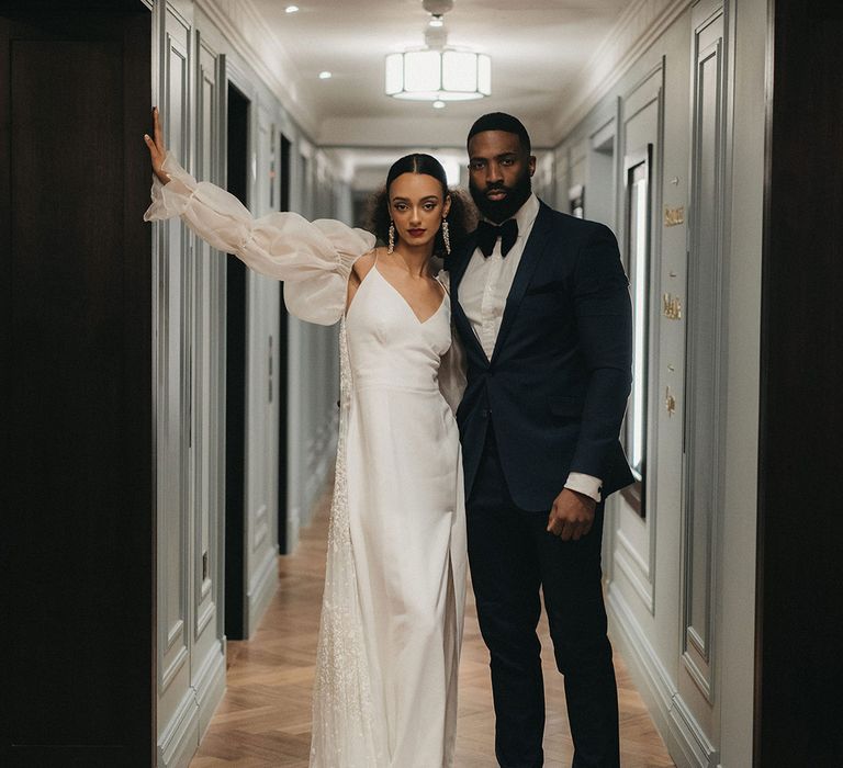 Black bride and groom at Mayfair Townhouse contemporary wedding with tuxedo suit and slip wedding dress