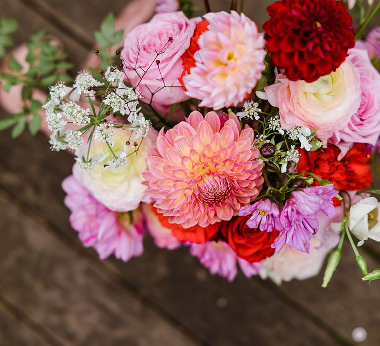 Pink and red wedding flowers including roses and dahlias for fun party wedding in the city 