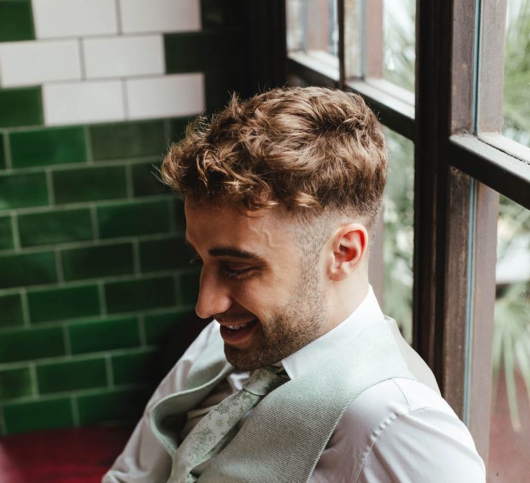 groom in a pale green waistcoat and paisley tie 