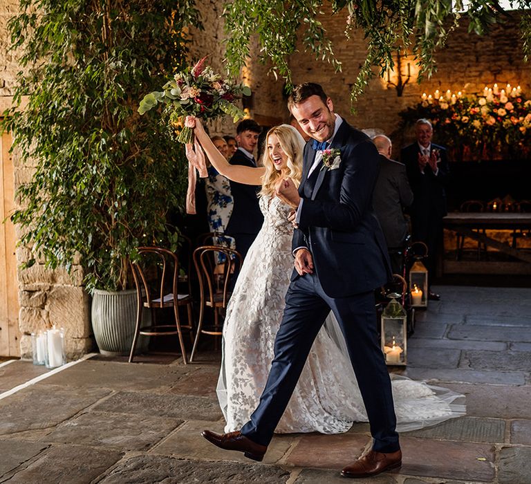 Bride and groom celebrate as they walk out of their wedding ceremony as a married couple