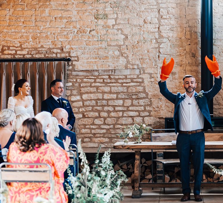 Groomsman reads out a speech as he waves around lobster claws on his hands 