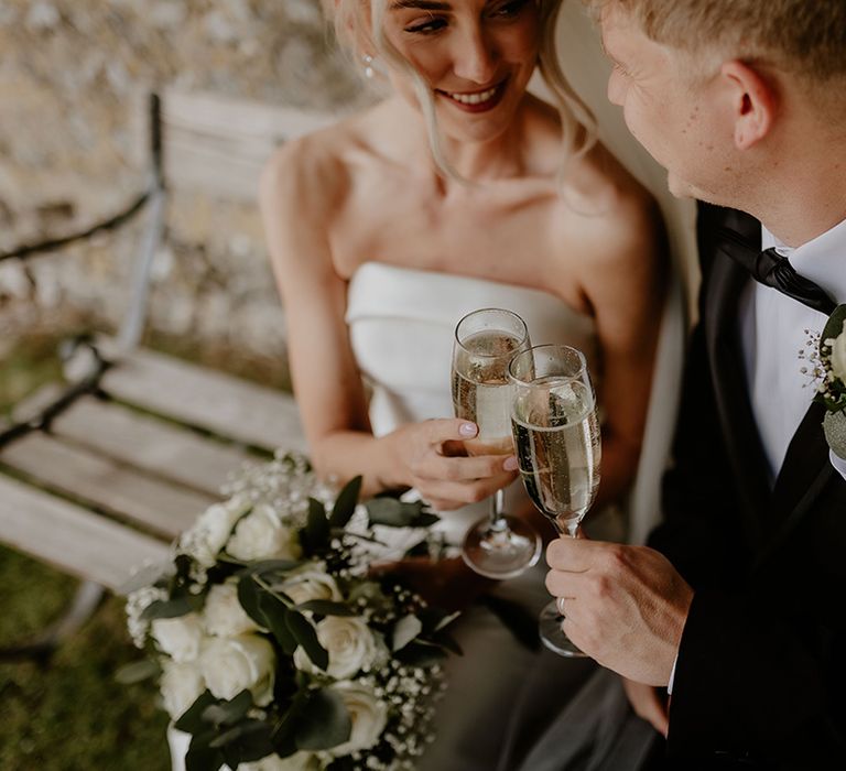 Bride and groom share a private moment and cheers their glasses of Prosecco after getting married 