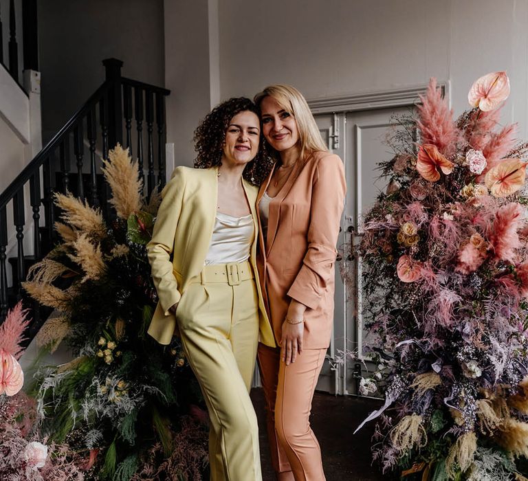 yellow and peach bridesmaids suits at modern and stylish London wedding with pastel coloured column floral arrangements 