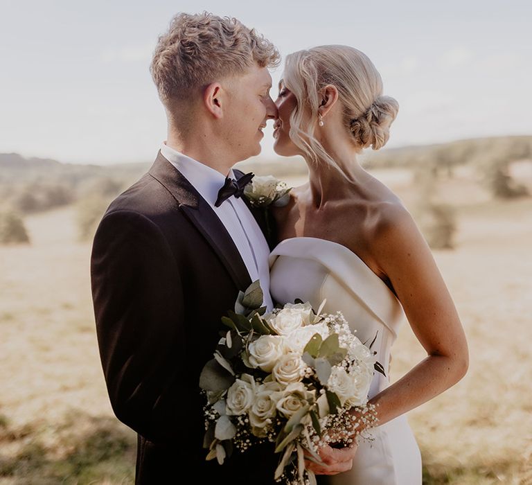 Bride and from pose together for their couple portraits as they lean in for a kiss