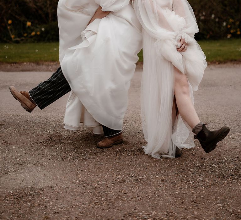 Two brides in floaty wedding dresses with boots at Mapledurham wedding venue in Oxfordshire 