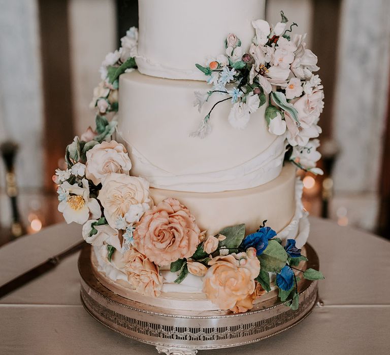 Three tier white frosted wedding cake with floral decoration 