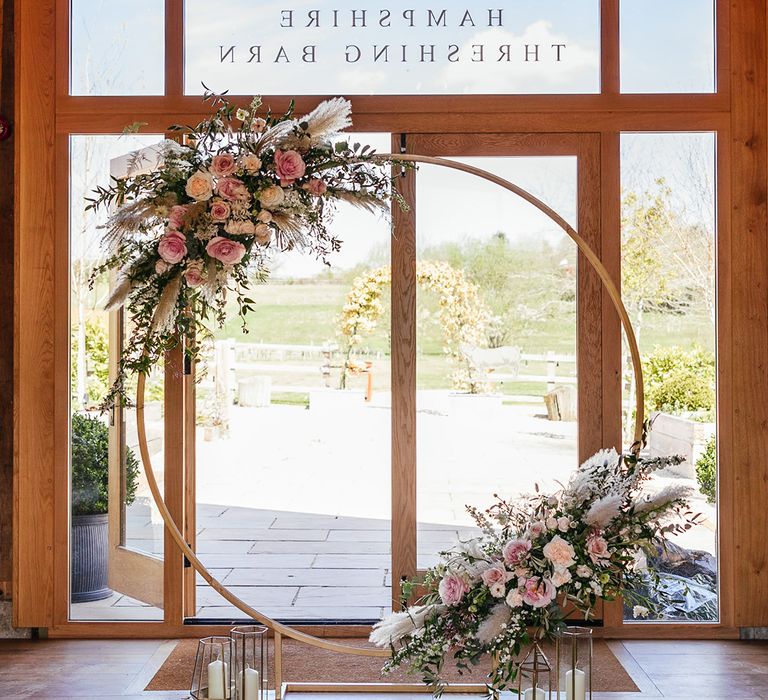 Pink and white rose floral moongate with dried grasses and pretty candles 