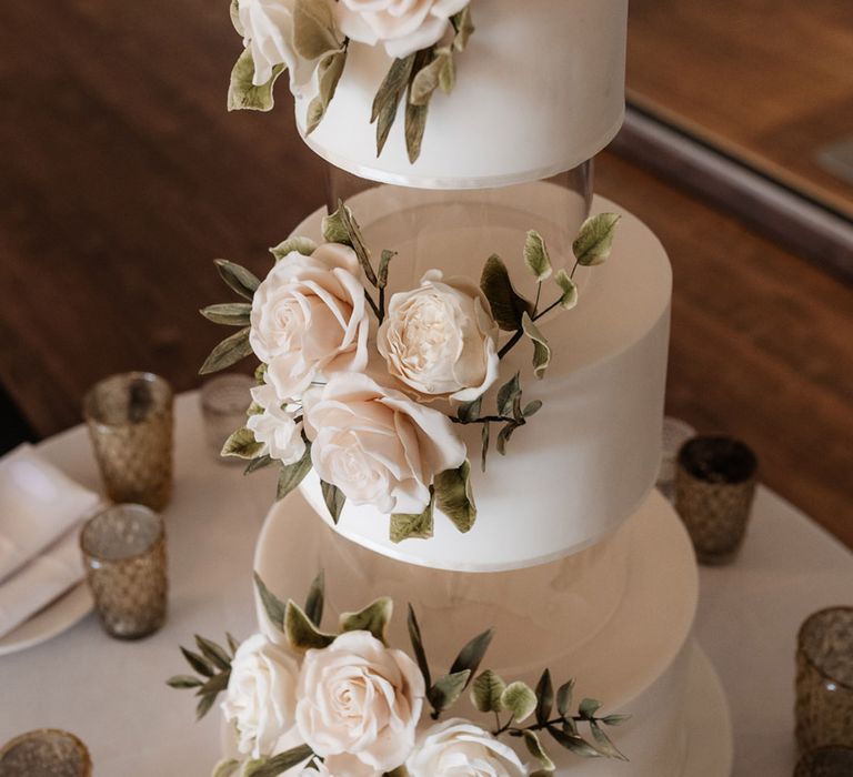 Three tier classic white cake complete with white rose decor 