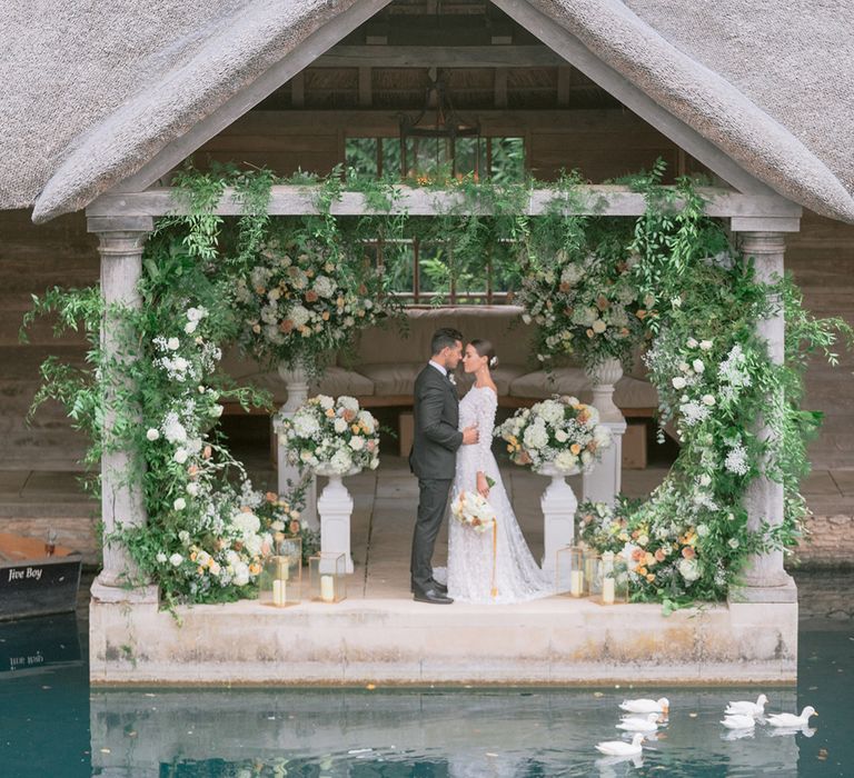 Yellow wedding flowers decorate the outdoor ceremony area with pillar candles for the bride and room's black tie wedding 