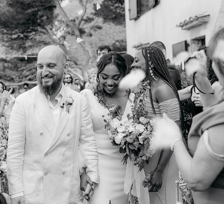 Bride and Groom walk though confetti at Torre de Bosis wedding venue in Portonovo, Italy