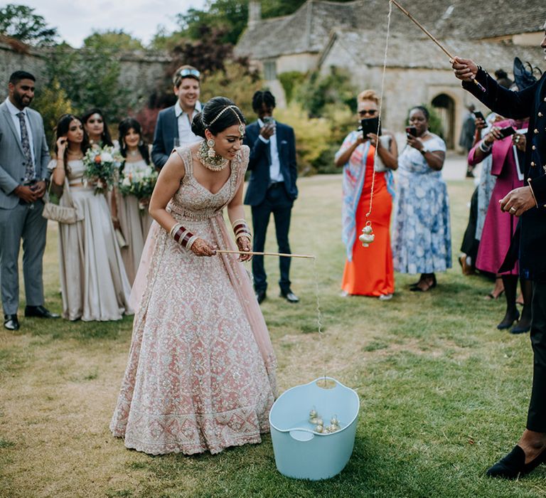 Bride and Groom play wedding games surrounded by wedding guests and wedding party