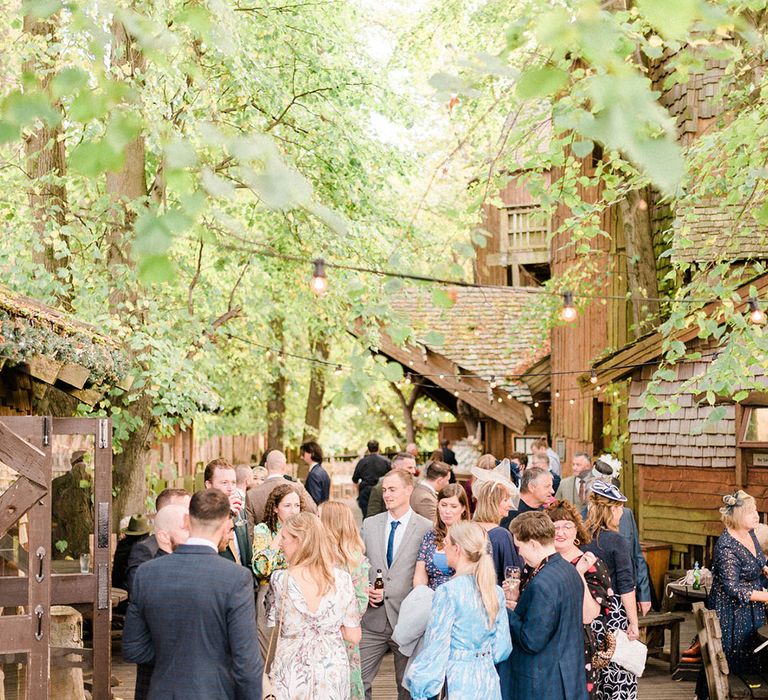 Wedding guests gather outdoors at the Alnwick Garden Treehouse wedding venue 