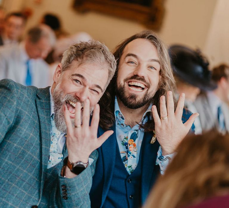 Grooms show off their wedding bands after ceremony at the Cambridge Cottage in Kew Gardens 