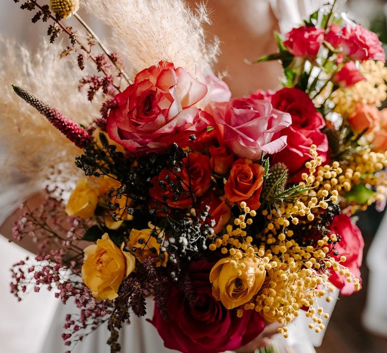 Pink garden rose, pampas grass, carnations, baby's-breath, dried flower and foliage bridal bouquet with sheer white lace ribbon