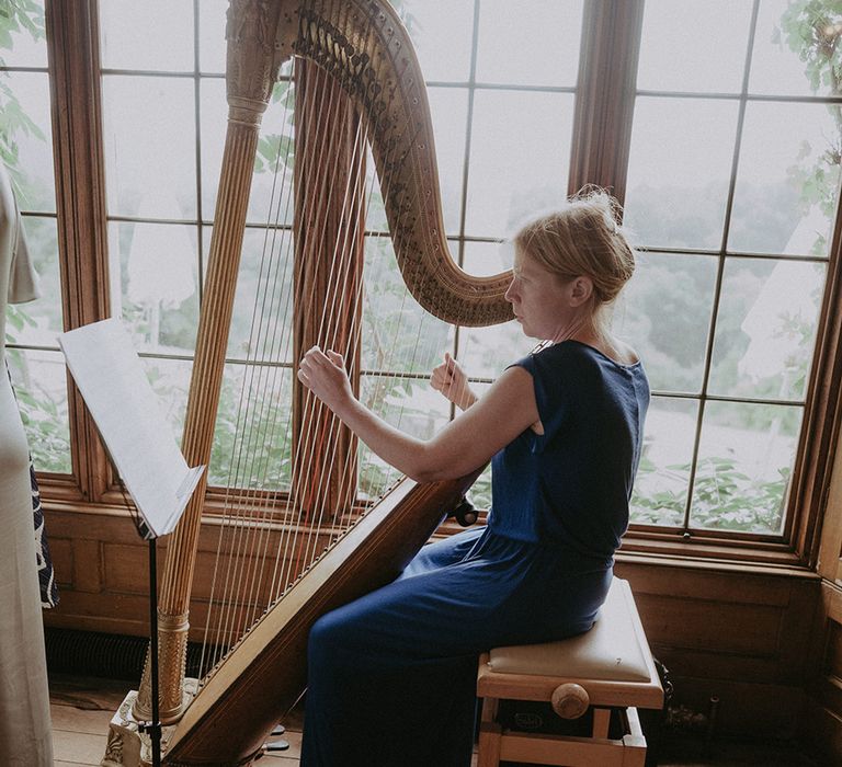 A harpist plays during the wedding ceremony as the bride and groom commit their lives to each other 