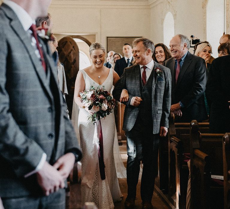 Father of the bride in three piece grey checkered suit walking the bride in a Karen Willis Holmes wedding dress does the aisle 