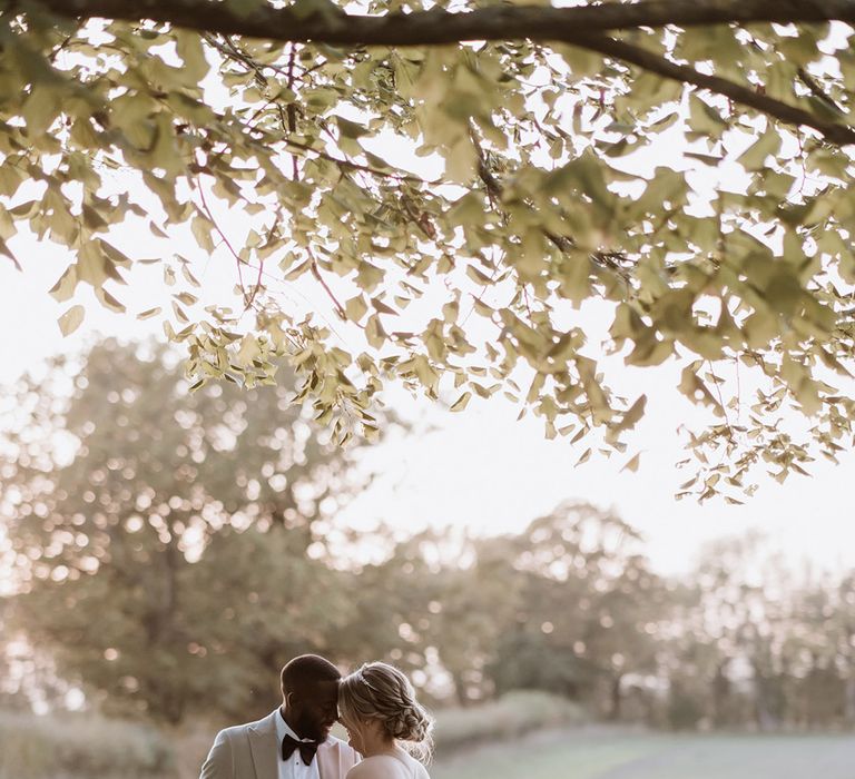 Rustic Colville Hall wedding in Essex with the bride and groom posing for their cute couple portraits outside 