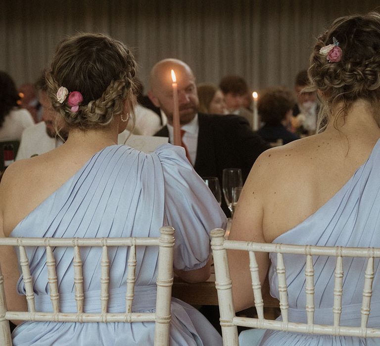 Bridesmaids in one shoulder blue bridesmaid dresses sitting for the wedding breakfast 