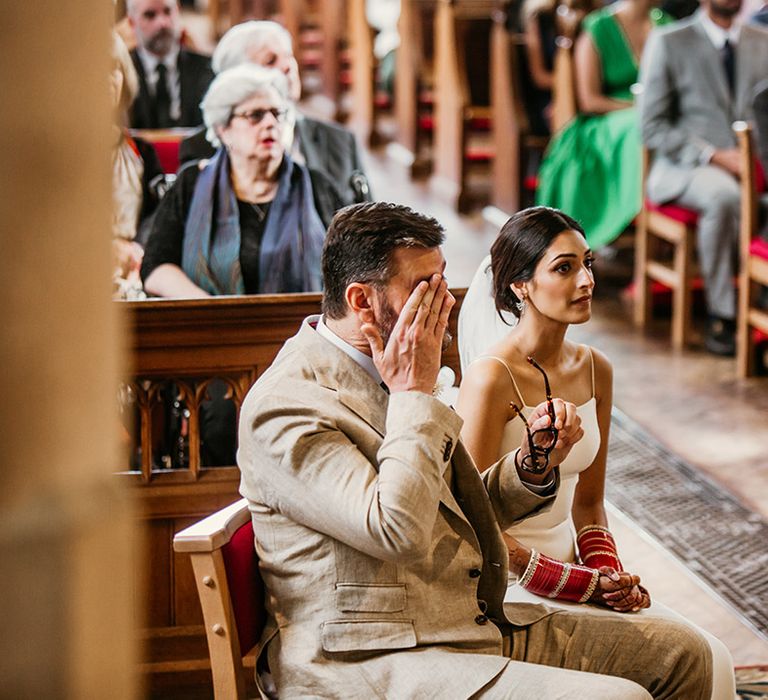 The bride and groom sit for their Italian-Catholic wedding ceremony 