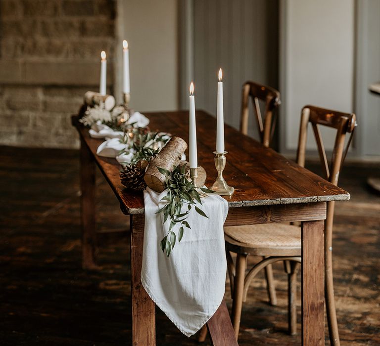 Wedding registry table with white drapery, logs, and foliage 