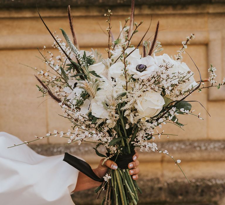 Winter wedding bouquet with white flowers including roses and anemones 