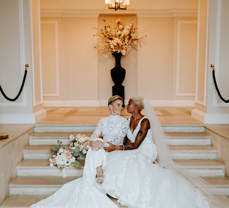 Traditional and timeless wedding fashion with two brides wearing lace gowns 