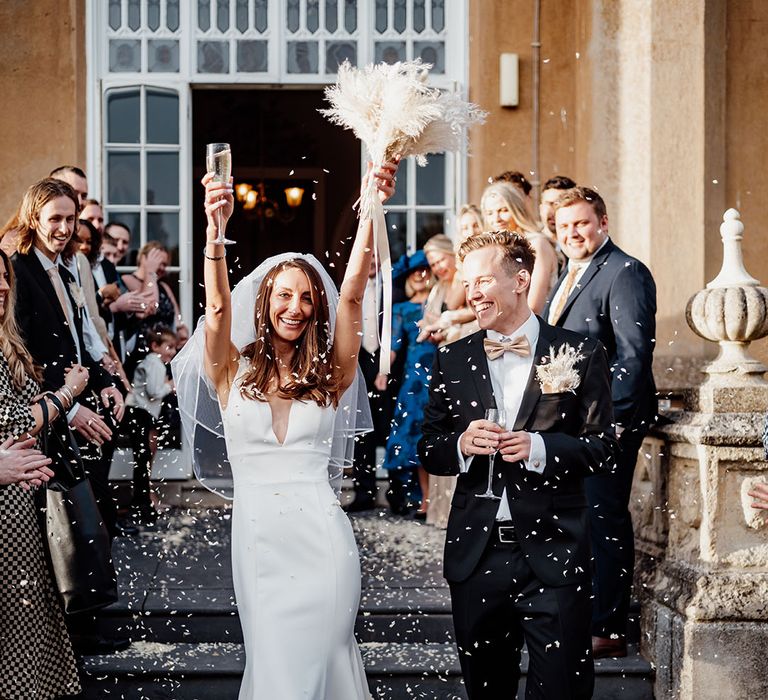 Confetti moment for the bride and groom with champagne as they celebrate their wedding 