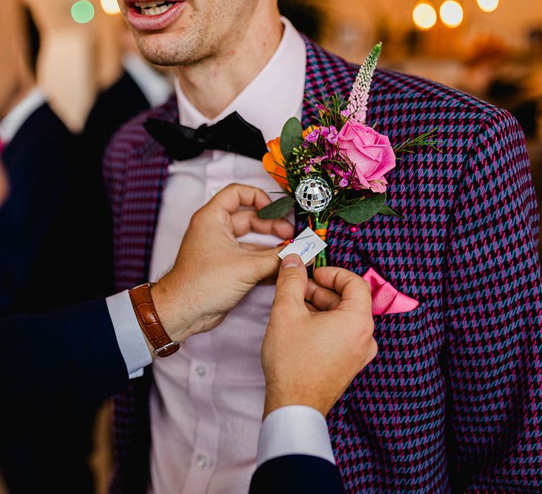 Purple and black checkered suit for groom with flower buttonhole 